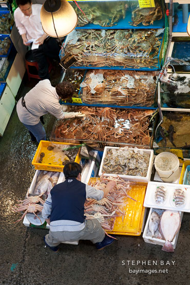 Vendors check the crabs (ge) they are selling in their stall at the Noryangjin Fish Market in Seoul.
