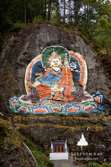 Large painting of Guru Rinpoche on a rock face. Road from Thimphu to Punakha, Bhutan.