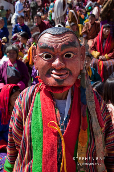 A clown (atsara) moves through the audience to collect donations. Thimphu tsechu, Bhutan.