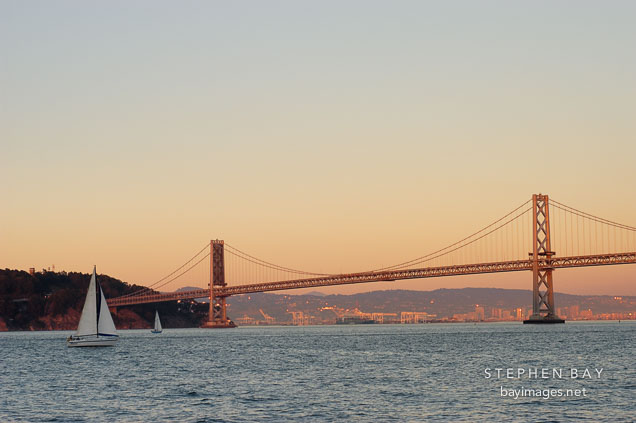 Sailboat and the Oakland Bay Bridge. San Francisco, California.