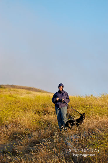 Woman hiking with a dog. Mission Peak, Fremont, California, USA.