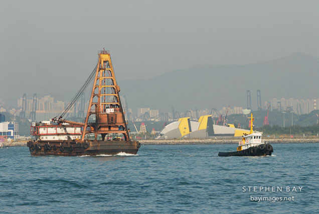 Tugboat pulling barge. Victoria Harbor, Hong Kong, China.