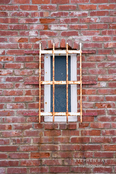 Barred window and brick wall. Santa Cruz Lighthouse, California.