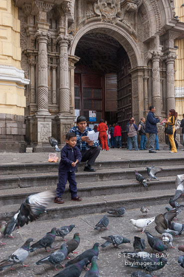 Boy feeding pigeons. Lima centro, Peru.