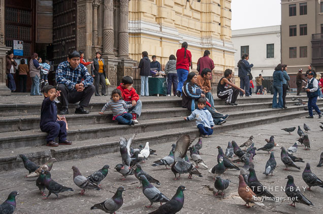 People sitting on the the steps of San Francisco Church. Lima
