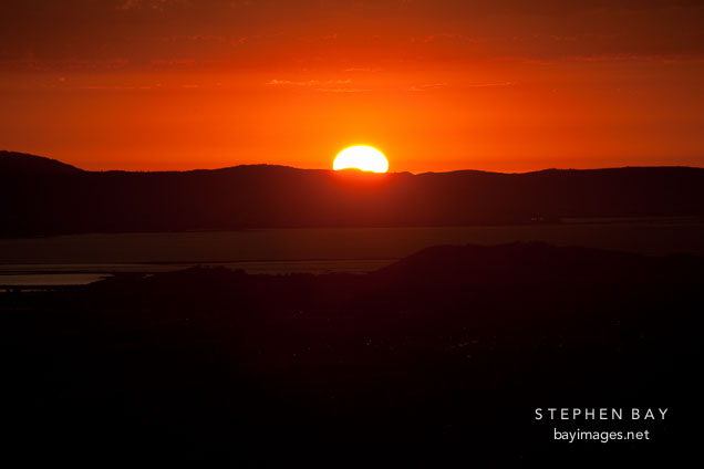 Sun disappearing over the horizon. San Francisco Bay, California.