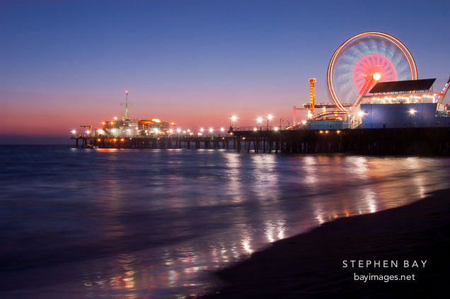 Bright lights of the Santa Monica pier and ferris wheel. Santa Monica, California, USA.