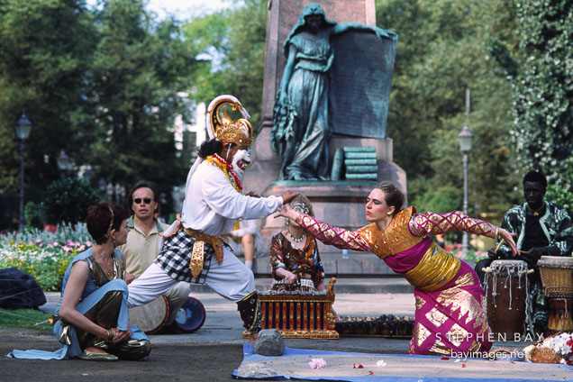 Man in monkey costume reaches out to the golden woman. Helsinki, Finland.