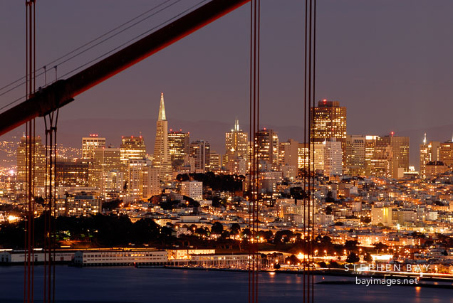 San Francisco skyline as seen through the cables of the Golden Gate Bridge. San Francisco, California, USA.