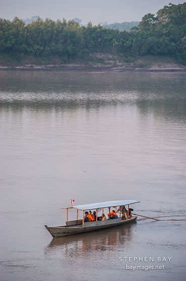 Boat ferrying tourists. Madre de Dios river, Peru, South America, vertical