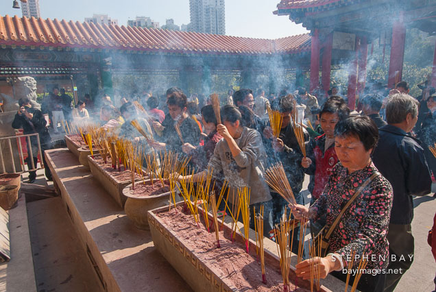Large crowds of people light incense for their ancestors at the Wong Tai Sin Temple. Hong Kong, China.