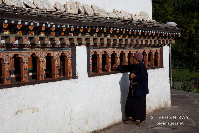 Woman spinning the prayer wheels of Chorten Lhakhang. Paro, Bhutan.