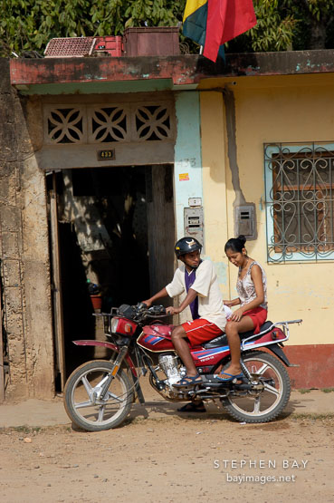 Male driver and a female passenger on a motorcycle taxi. Puerto Maldonado, Peru.