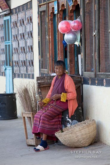 Old woman with hand held prayer wheel. Paro, Bhutan.