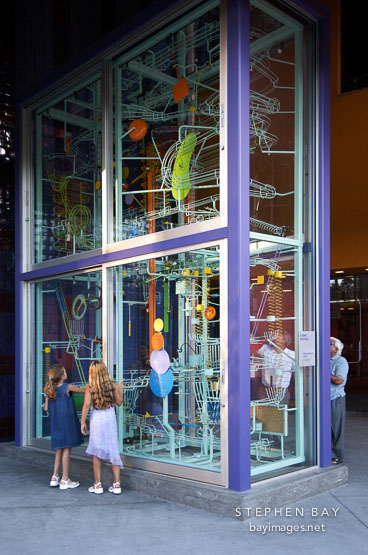 Girls examing the billiard ball display at the Tech Museum. San Jose, California, USA.