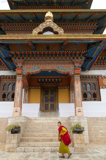 Khamsum Yuelley Namgyal Chorten and nun walking. Punakha valley, Bhutan.