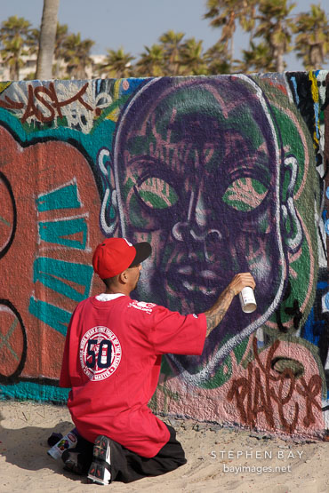 Young man creating graffiti. Venice, California, USA.