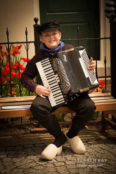 Boy in Dutch clothing playing accordion during the Tulip-Time festival. Pella, Iowa.