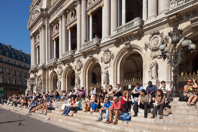 Office workers enjoying a break on the steps of the Paris Opera house. Paris, France.