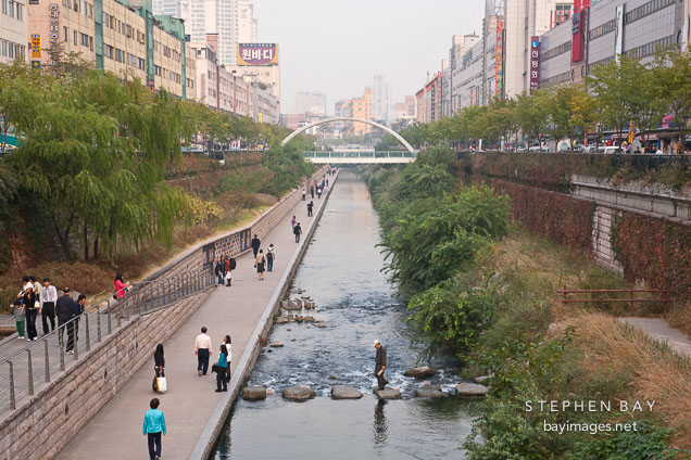 Pedestrians walking through Cheonggyecheon. Seoul, Korea.