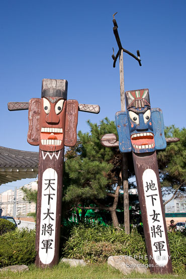 Jangseung (spirit sticks) are placed at the edge of a village to scare away demons. Suwon, South Korea.