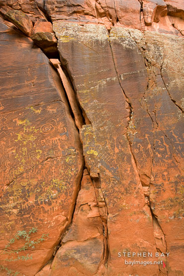 Petroglyphs on the cracked rock wall. V-Bar-V Ranch, Arizona, USA.