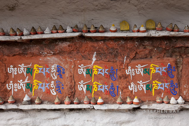 Mini stupa and Buddhist chant (Om mani padme hum) written on a mani wall. Dochu La, Bhutan.