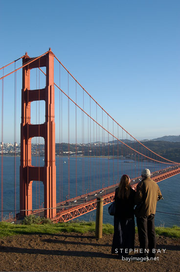 Couple enjoying the view of the Golden Gate Bridge. San Francisco, California.