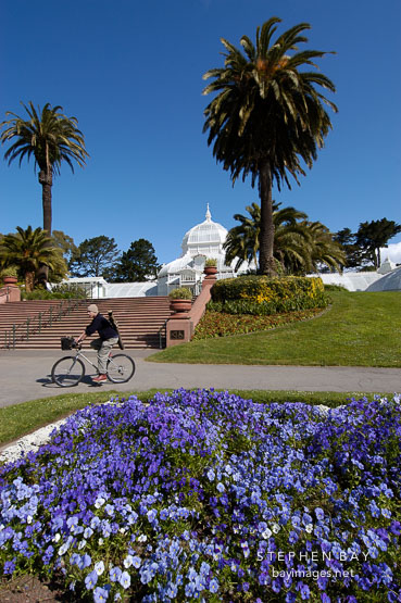 Man bicycling at the Conservatory of Flowers. Golden Gate Park, San Francisco, California, USA.