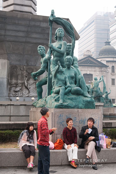 Shoppers take a break next the Bank of Korea fountain in central Seoul, South Korea.