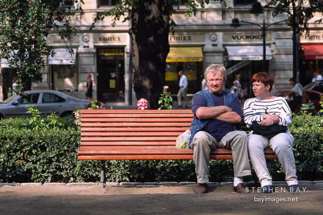 Couple sitting on a bench. Runeberg Esplanadi. Helsinki, Finland.