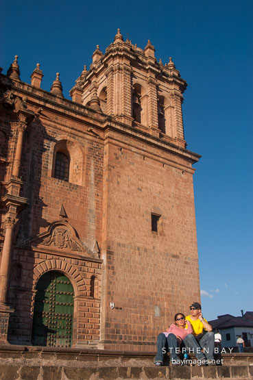 Couple sitting in front of the Cathedral. Cusco, Peru.