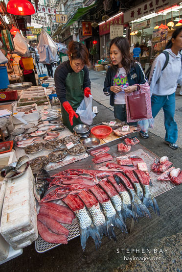 Chinese woman buying fish. Central, Hong Kong, China.