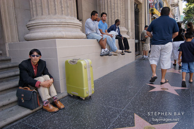 Waiting with a green suitcase. Hollywood, California, USA.