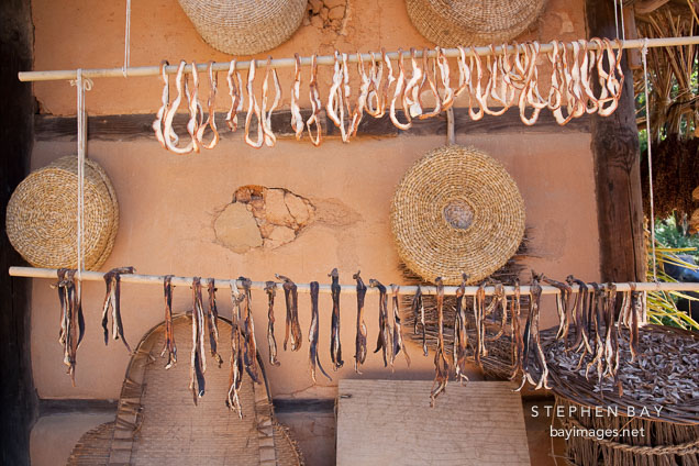 Herbs and spices hang outside a small home to dry in the sun.