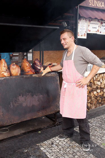 Man cooking roast pork on barbeque. Prague, Czech Republic.
