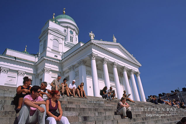 People sitting on the steps of the Cathedral. St. Nicholas' Church. Helsinki, Finland.