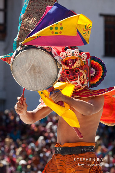 Ging dancer with terrifying mask beating a drum. Thimphu tsechu, Bhutan.