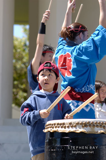 Child learning to play the Taiko drums. Cherry blossom festival, Japantown, San Francisco, California, USA.