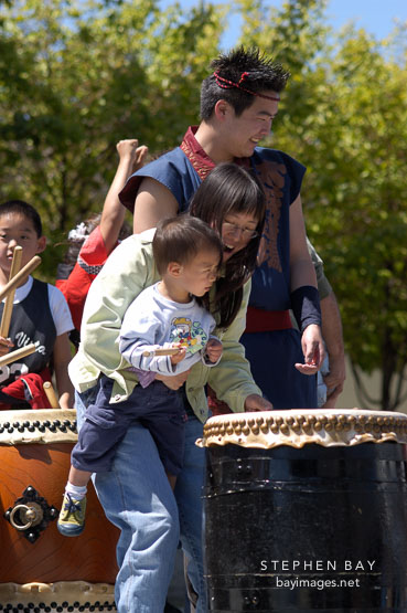 Mother and son trying Taiko drums. Cherry blossom festival. Japantown, San Francisco, California, USA.