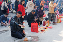 Man offering alcohol and food for the deceased. Wong Tai Sin Temple, Hong Kong, China. - Photo #15718