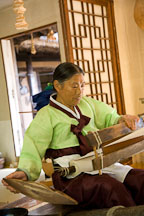 Weaving cotton into cloth using a hand loom is very labor intensive. This woman demonstrates the process at the Korean Folk Village. - Photo #20429