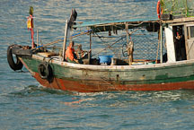 Man on fishing boat in Victoria Harbor. Hong Kong, China. - Photo #15630