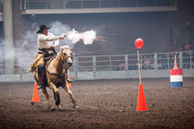 Cowboy fires gun at balloon targets during the mounted shooting contest. Iowa State Fair, Des Moines. - Photo #33038