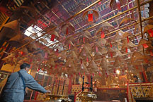 Man placing incense in pot. Man Mo Temple, Hong Kong, China. - Photo #15138