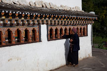 Woman spinning the prayer wheels of Chorten Lhakhang. Paro, Bhutan. - Photo #24341