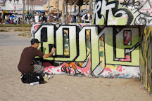 Man spray painting a wall with his inscription. Venice, California, USA. - Photo #7462