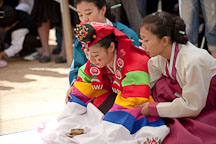 A Korean bride is supported by her friends as she bows as part of this traditional wedding ceremony at the Korean Folk Village. - Photo #20507