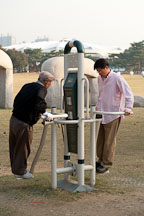 Park goers utilize some of the exercise equipment that can be found in Olympic Park in Seoul, South Korea. - Photo #21683