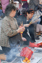 Woman shaking fortune sticks. Wong Tai Sin Temple, Hong Kong, China. - Photo #15685